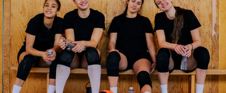 Four female athletes on a bench
